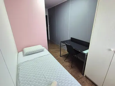a small room with a bed and a desk at Hostel M in Maribor