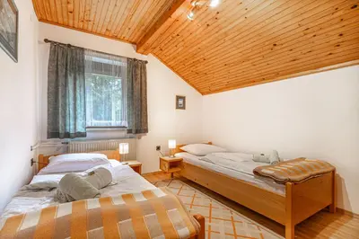 two beds in a room with a wooden ceiling at House Mavko Near Lake Cerknica - Happy Rentals in Grahovo