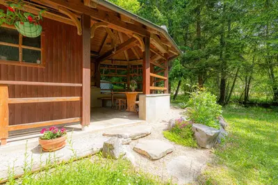 a wooden cabin with a porch and a table in it at House Mavko Near Lake Cerknica - Happy Rentals in Grahovo