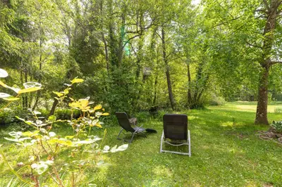 two chairs sitting in the grass in a garden at House Mavko Near Lake Cerknica - Happy Rentals in Grahovo