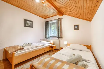 two beds in a room with a wooden ceiling at House Mavko Near Lake Cerknica - Happy Rentals in Grahovo