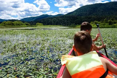 two boys in a kayak on a body of water at House Mavko Near Lake Cerknica - Happy Rentals in Grahovo