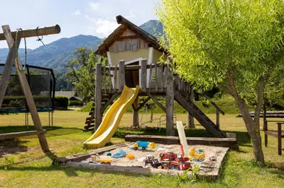 a playground with a slide and a play house at Chalet Pr Dobravc in Bohinj