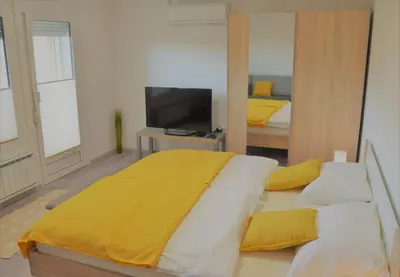 a bedroom with a large bed with a yellow blanket at Apartma Vila Zigmund in Cerknica
