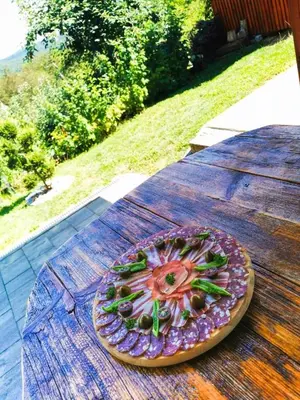 a plate of food sitting on top of a wooden table at Vineyard cottage Na hribu in Dvor