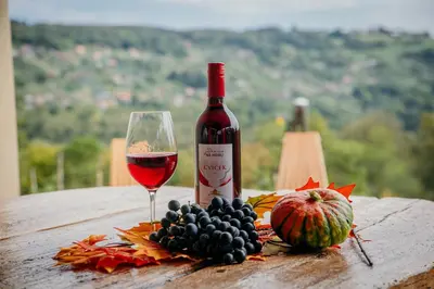 a bottle of wine and a glass on a table at Vineyard cottage Na hribu in Dvor