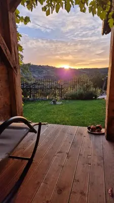 a wooden deck with a view of the sunset at Vineyard cottage Na hribu in Dvor