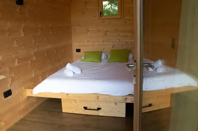 a bedroom with a bed in a wooden room at Hiška-Glamping in Ajdovščina