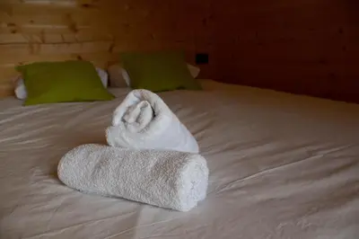 a white towel laying on top of a bed at Hiška-Glamping in Ajdovščina