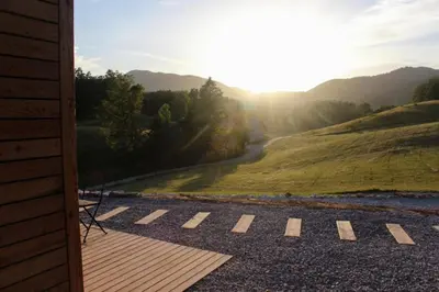 a view from the porch of a house with the sun setting at Hiška-Glamping in Ajdovščina