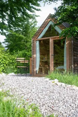 a wooden cabin with a bench in front of it at Hiška-Glamping in Ajdovščina