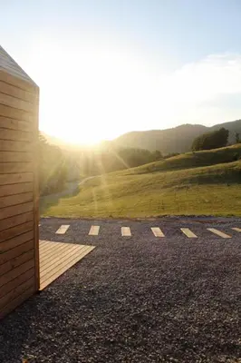 a room with a view of a field with the sun shining at Hiška-Glamping in Ajdovščina