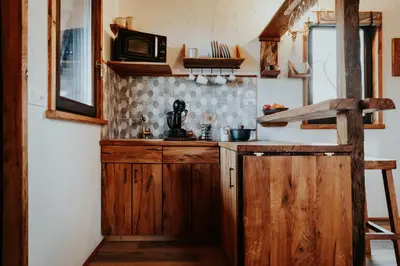 a kitchen with wooden cabinets and a counter top at Treehouse Drevesna hiška Štrkovo gnezdo Ranč Jureš in Ljutomer