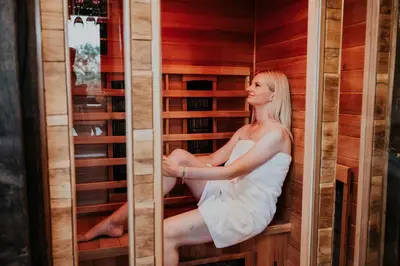 a woman is sitting in a sauna at Treehouse Drevesna hiška Štrkovo gnezdo Ranč Jureš in Ljutomer