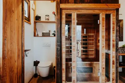 a bathroom with a toilet and a glass door at Treehouse Drevesna hiška Štrkovo gnezdo Ranč Jureš in Ljutomer