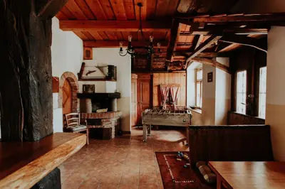 a living room with wooden ceilings and a table at Treehouse Drevesna hiška Štrkovo gnezdo Ranč Jureš in Ljutomer