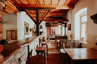 a bar in a restaurant with wooden ceilings and stools at Treehouse Drevesna hiška Štrkovo gnezdo Ranč Jureš in Ljutomer