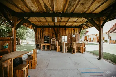 a large wooden pavilion with wooden tables and benches at Treehouse Drevesna hiška Štrkovo gnezdo Ranč Jureš in Ljutomer