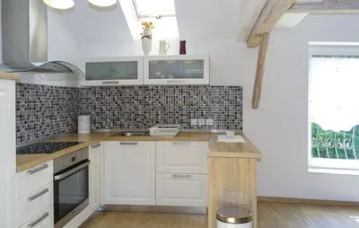 a kitchen with white cabinets and a sink and a window at Apartmaji Čujež in Rečica ob Savinji