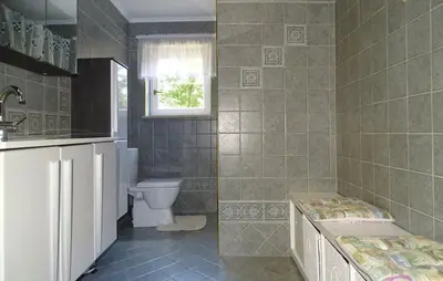 a bathroom with a tub and a toilet and a window at Apartmaji Čujež in Rečica ob Savinji