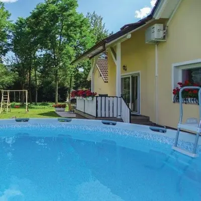 a large blue swimming pool in front of a house at Apartmaji Čujež in Rečica ob Savinji