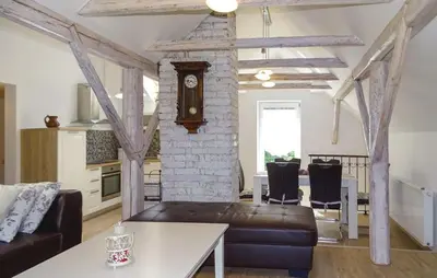 a living room with a couch and a clock in a room at Apartmaji Čujež in Rečica ob Savinji