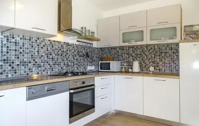 a white kitchen with white cabinets and appliances at Apartmaji Čujež in Rečica ob Savinji