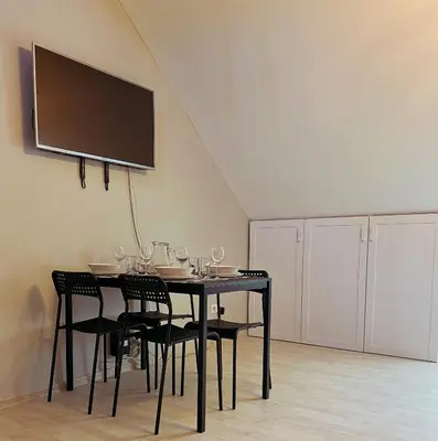 a black dining room table with chairs and a flat screen tv at Apartment 31 Vila Golf Nice Vacation in Rogaška Slatina