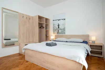 a bedroom with a large bed and a large window at Viva Rooms in Ljubljana