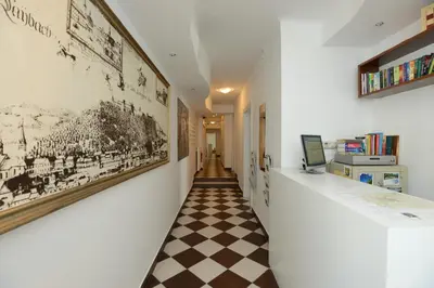 a hallway with a checkered floor and posters on the walls at Viva Rooms in Ljubljana