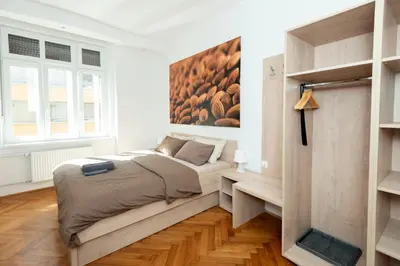 a bedroom with a bed and a painting on the wall at Viva Rooms in Ljubljana