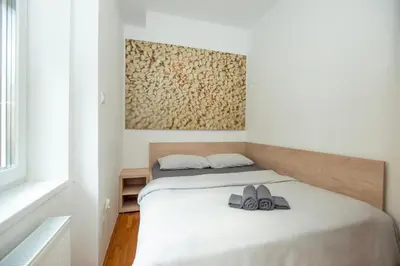 a bedroom with a bed with two shoes on it at Viva Rooms in Ljubljana
