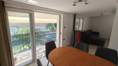a dining room with a table and a sliding glass door at Apartma Apollonio in Črni Kal