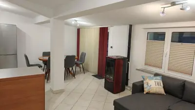 a living room with a couch and a kitchen and a table at Apartma Apollonio in Črni Kal