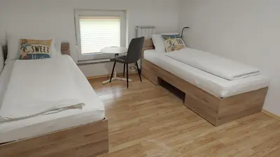 a bedroom with two beds and a desk and a chair at Apartma Apollonio in Črni Kal