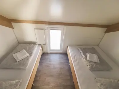 two beds in a small room with a window at Three Stars Luxury House ART-PE with pool and SPA pool in Trebnje
