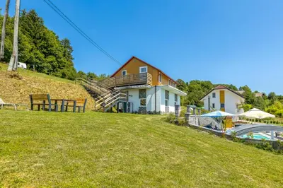 a house on top of a grassy hill at Three Stars Luxury House ART-PE with pool and SPA pool in Trebnje