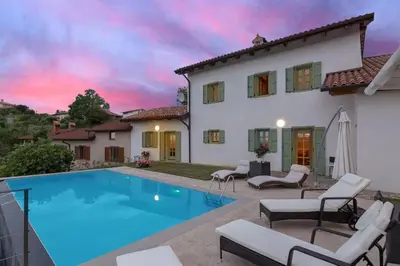 a villa with a swimming pool in front of a house at Pool & Sauna Villa Gizela - Happy Rentals in Kojsko