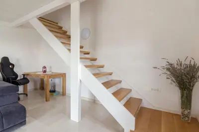 a white staircase in a living room with a blue couch at Pool & Sauna Villa Gizela - Happy Rentals in Kojsko