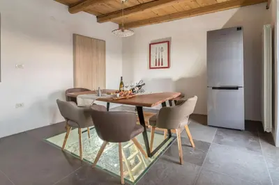 a kitchen and dining room with a wooden table and chairs at Pool & Sauna Villa Gizela - Happy Rentals in Kojsko