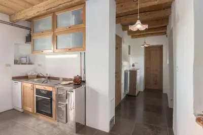 a kitchen with white walls and wooden ceilings at Pool & Sauna Villa Gizela - Happy Rentals in Kojsko