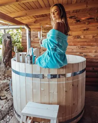 a woman sitting on top of a barrel at Room Oaza Miru in Maribor