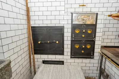 two black doors in a white tiled wall at Notranjska hiša - traditional country house, close to the world attraction Cerknica lake in Begunje pri Cerknici