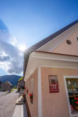 a building with a sign on the side of it at Notranjska hiša - traditional country house, close to the world attraction Cerknica lake in Begunje pri Cerknici