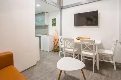 a living room with a table and chairs and a kitchen at Apartma N'Poznam Tobačna in Ljubljana