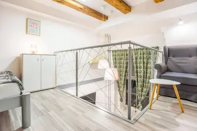 a living room with a couch and a chair at Apartma N'Poznam Tobačna in Ljubljana