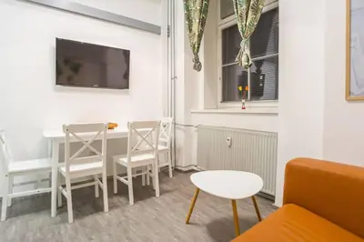 a living room with a table and chairs and a tv at Apartma N'Poznam Tobačna in Ljubljana