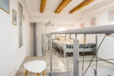 a bedroom with a bunk bed and a chair at Apartma N'Poznam Tobačna in Ljubljana