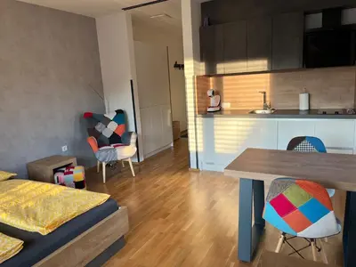 a kitchen and a living room with a table and chairs at DR7 Bled in Bled
