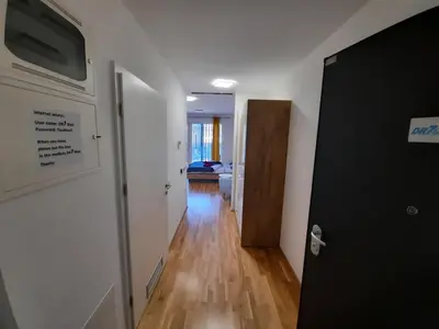 a hallway with a door to a room with wood floors at DR7 Bled in Bled
